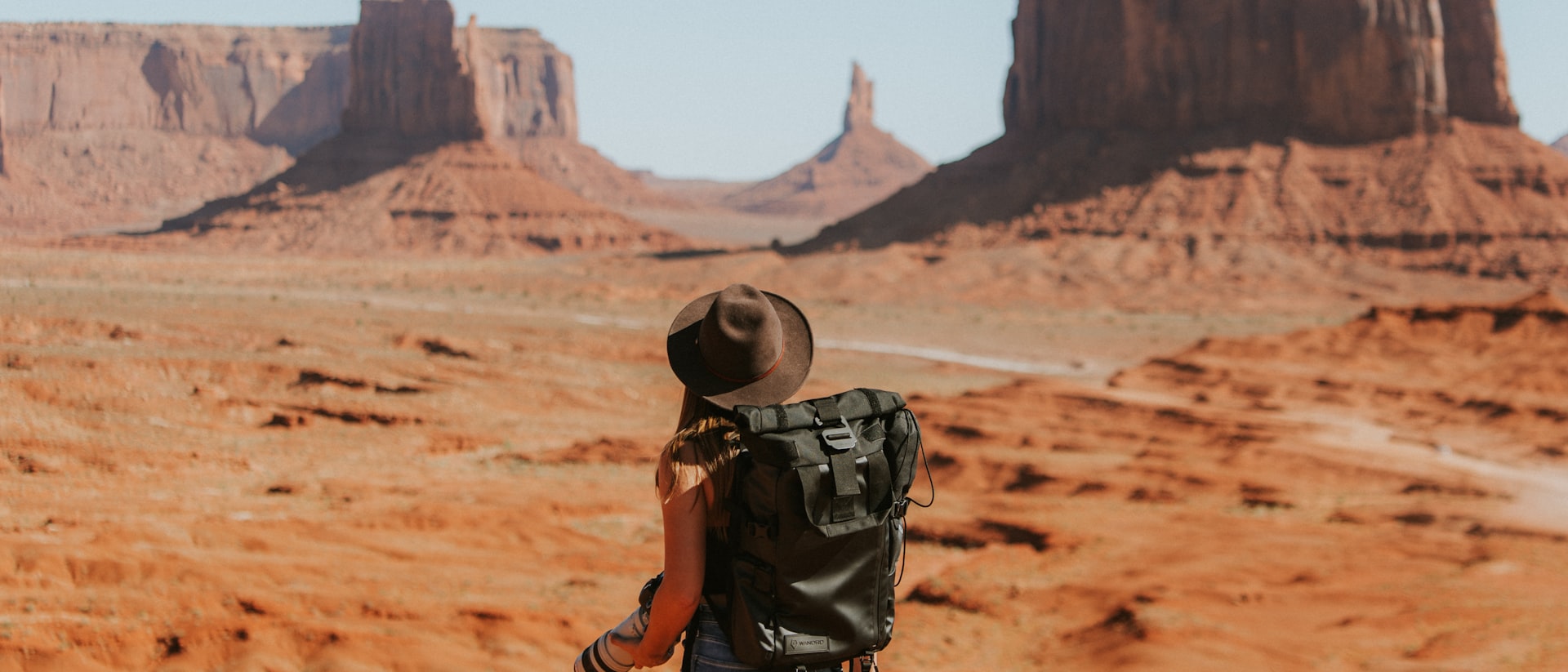 Glass-domed luxury railcar passing through the Canadian Rockies with snow-capped peaks and turquoise river below