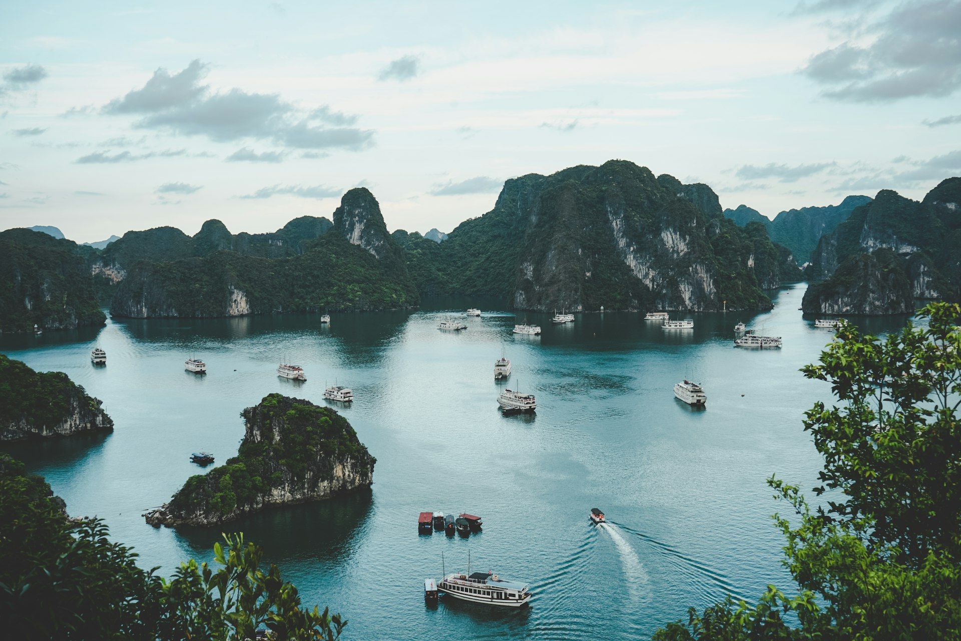 Traditional Vietnamese boat sailing through Ha Long Bay's limestone karsts