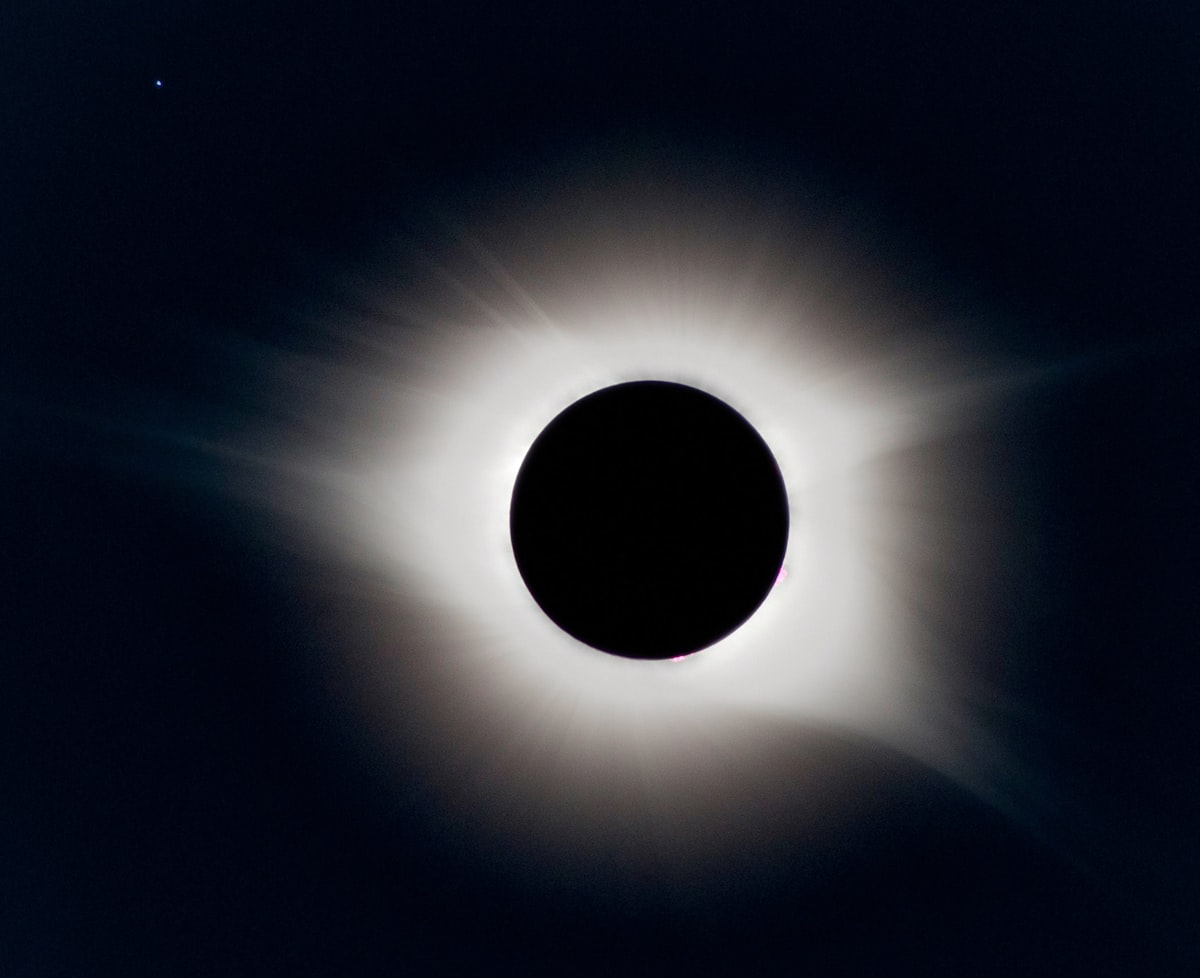 Total solar eclipse with corona visible against dark sky