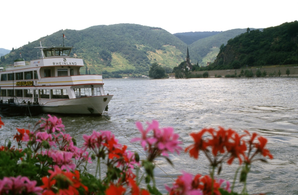 River cruise ship sailing past a medieval castle on the Rhine River in Germany