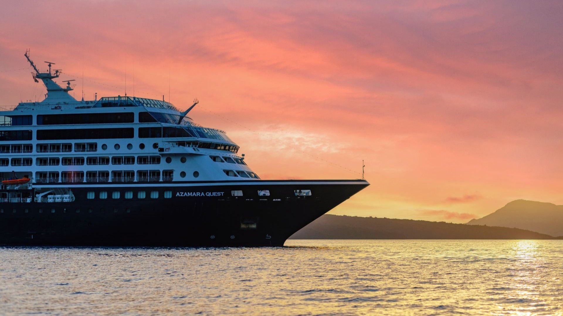 Azamara boutique cruise ship docked at a scenic European port at dusk