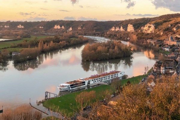 Uniworld boutique river cruise ship sailing through a European river landscape